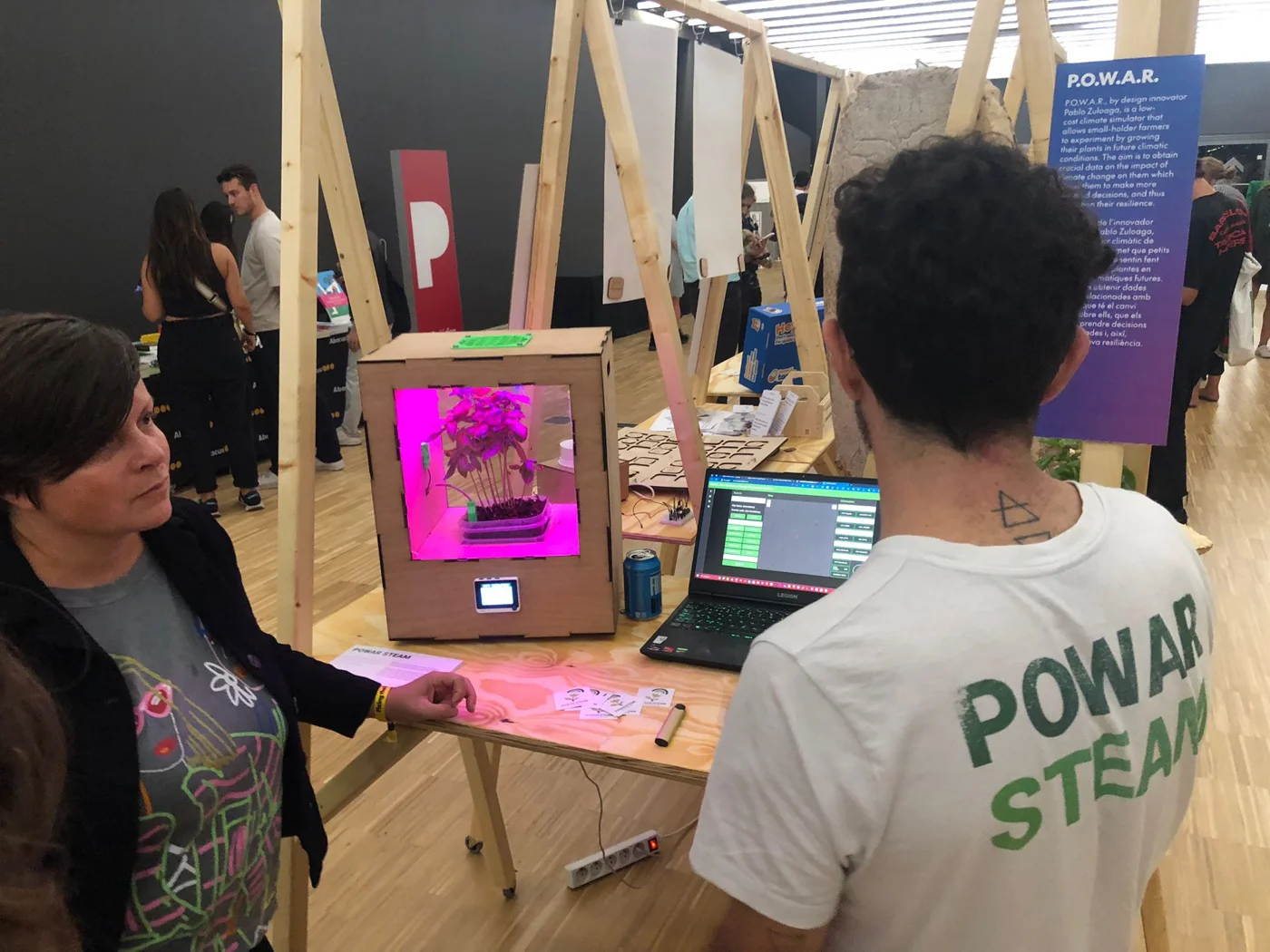 Visitantes en el stand de POWAR con el simulador de clima y el P-Bit